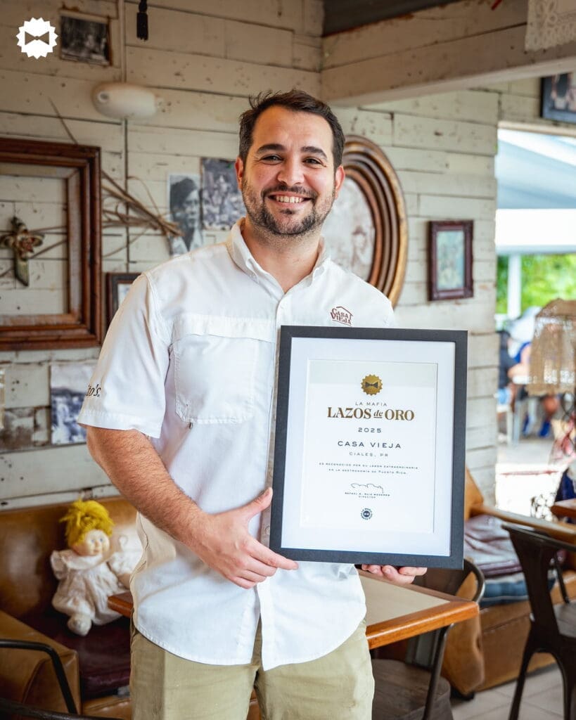 Restaurant owner holding Lazo de Oro award